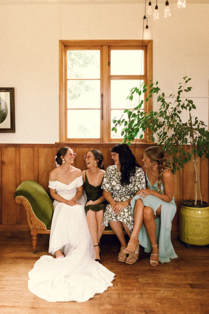 The bride and her bridesmaids share a laugh in the artsy air bnb before they are set to begin the wedding day in Apiti. Photo captured by Eilish Burt Photography