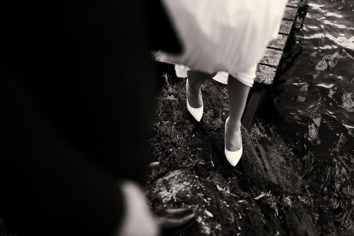 The bride and her groom walking off the rocks at Peppers on the point in rotorua. Vintage portrait taken by Eilish Burt