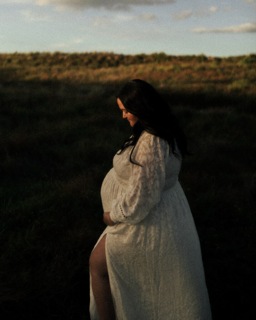 A pregnant mother holding her bump for her photoshoot with Eilish Burt Photography in Papamoa