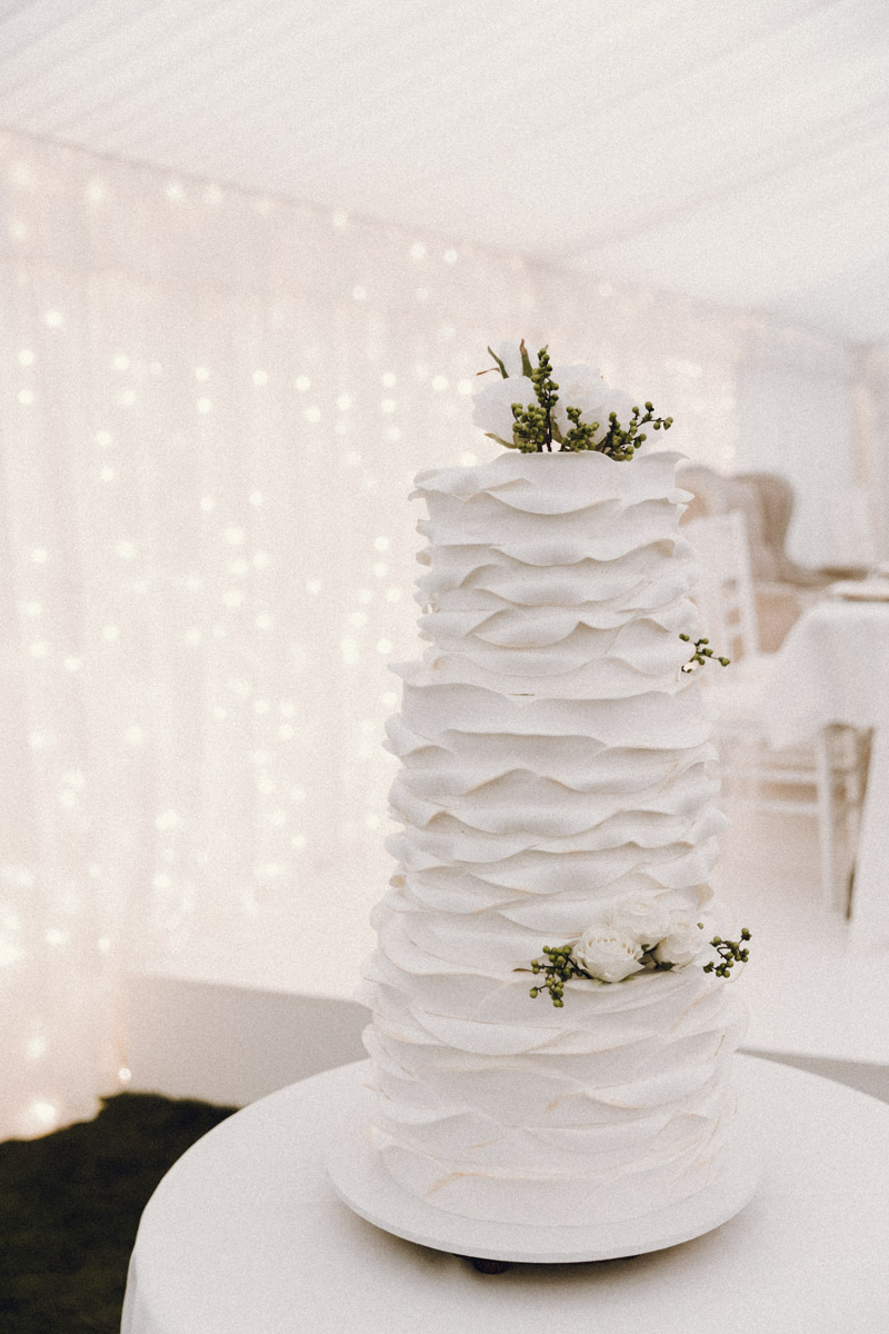 A 3 tiered white wedding cake captured by Whakatane's Eilish Burt Photography