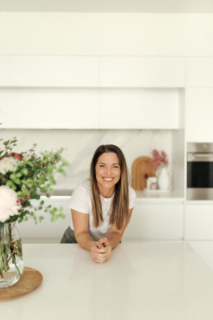 Michelle for Sweet Deer Hand Painted Wedding Cakes sits in her Whakatane kitchen for her business headshot captured by Eilish Burt Photography.