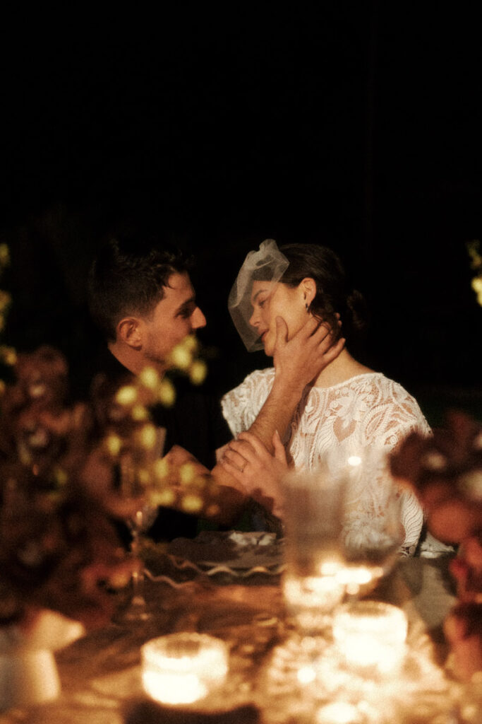 A romantic scene of a wedding couple at their candlelit dinner at the Puketutu Island Estate. Captured by Eilish Burt Photography