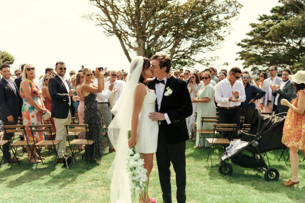Husband and wife share their first kiss at The Batch Winery on Waiheke Island.