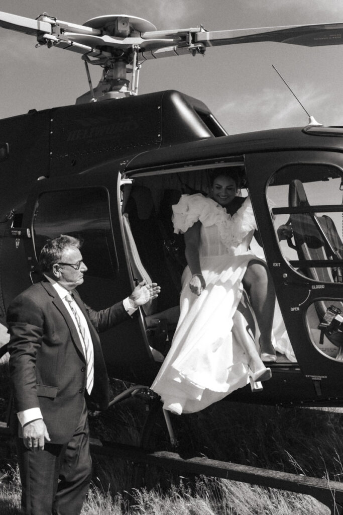 Bride arrives to her intimate wedding ceremony in Queenstown by a helicopter. Captured by Eilish Burt