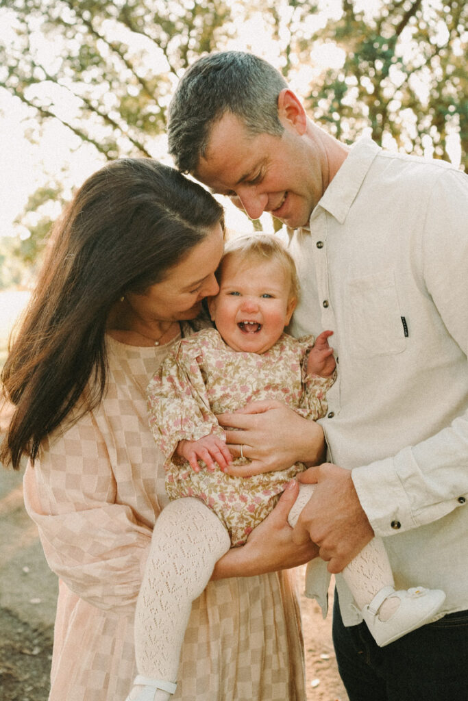 A fun family portrait of mum, dad and their daughter. Photographed in Ohope by Eilish Burt