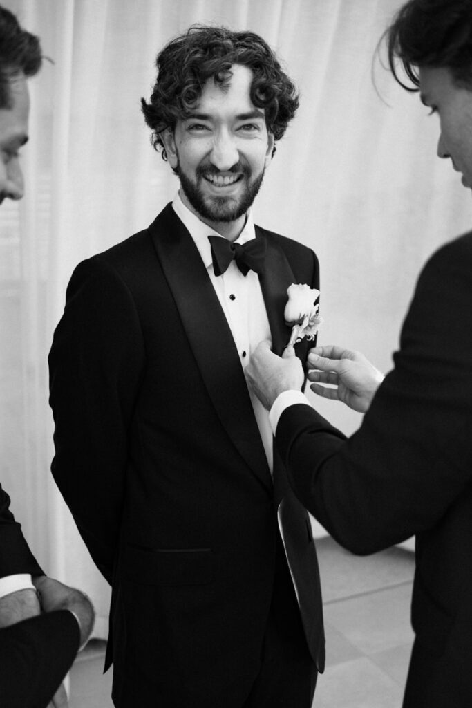 A vintage black and white portrait of the groom being suited for his wedding in Australia