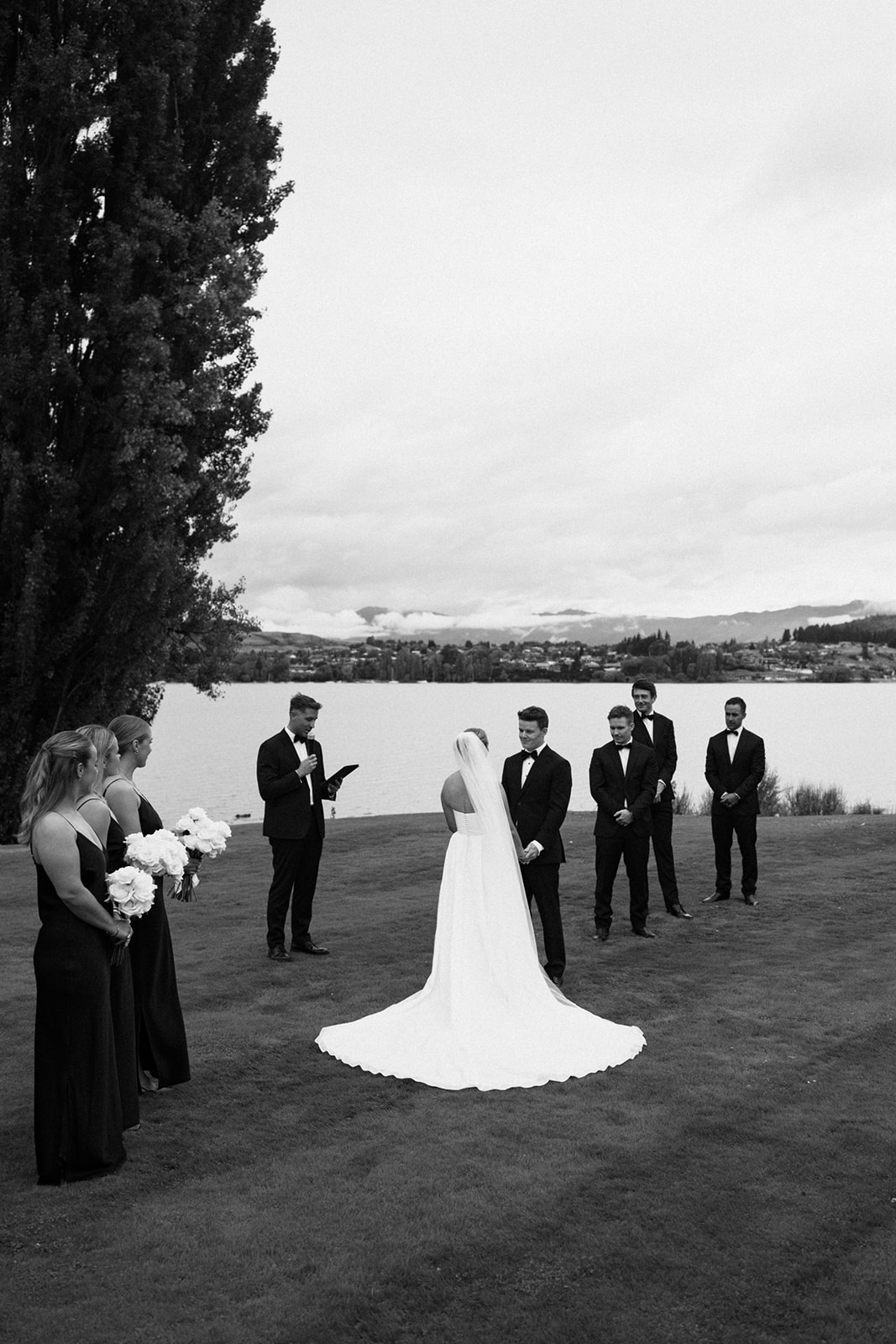 Bride and groom stand hand in hand at the end of the alter, waiting to have their first kiss at the Edgewater Estate in Wanaka.